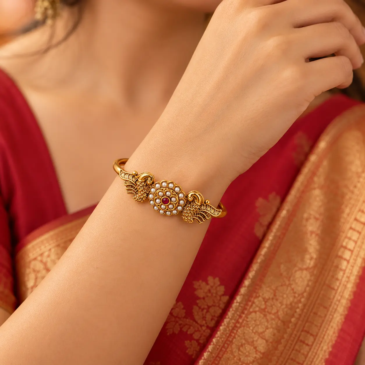 close_up_high_quality_warm_studio_style_photogra.png Antique Gold Tone Open Bangle with Pearl & Red Stone Detail – image 2