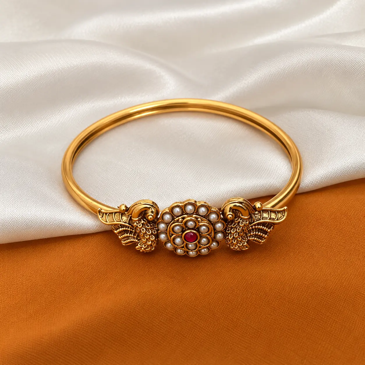 a_high_resolution_close_up_product_photography_sc.png Antique Gold Tone Open Bangle with Pearl & Red Stone Detail